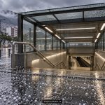 Ilustración con IA de una entrada genérica de metro con granizo en el pavimento