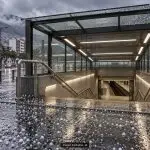 Ilustración con IA de una entrada genérica de metro con granizo en el pavimento
