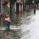 Personas caminan por una calle inundada en Ecuador