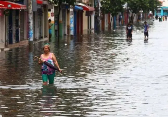 Personas caminan por una calle inundada en Ecuador