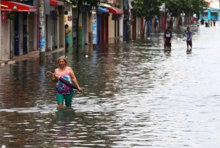Personas caminan por una calle inundada en Ecuador