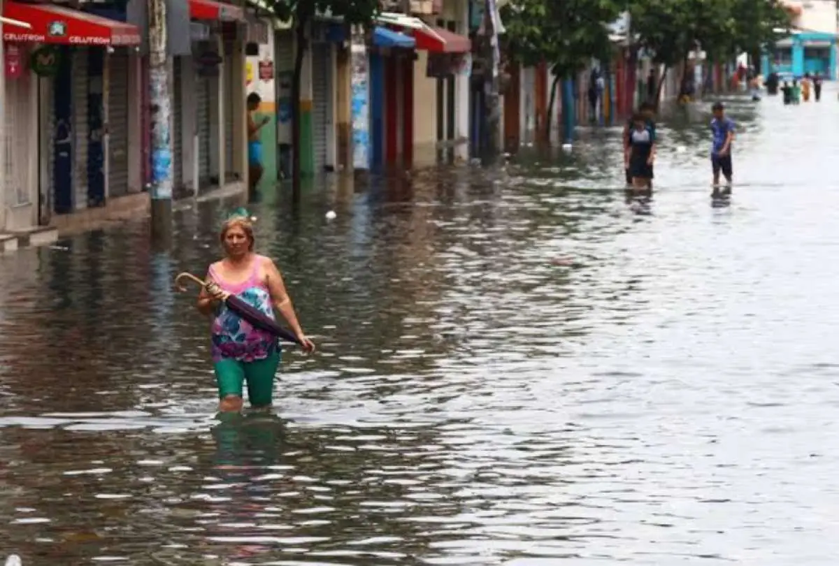 Personas caminan por una calle inundada en Ecuador